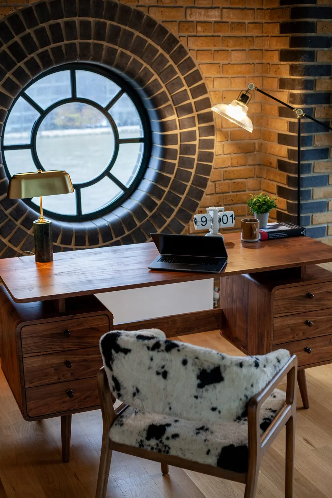 Desk under a round window in an LSE flat, London